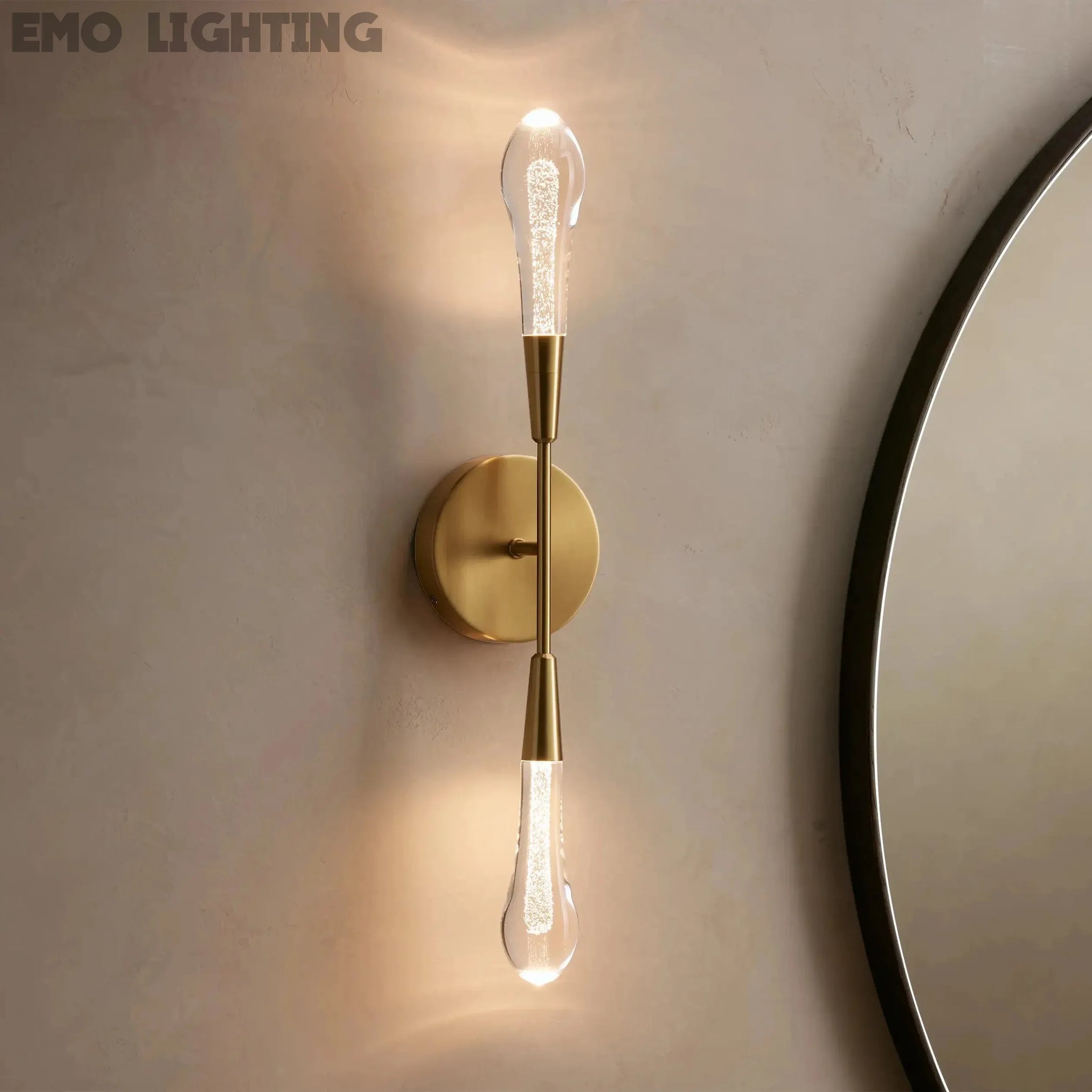 Gold wall sconce with a round mirror on a beige wall
