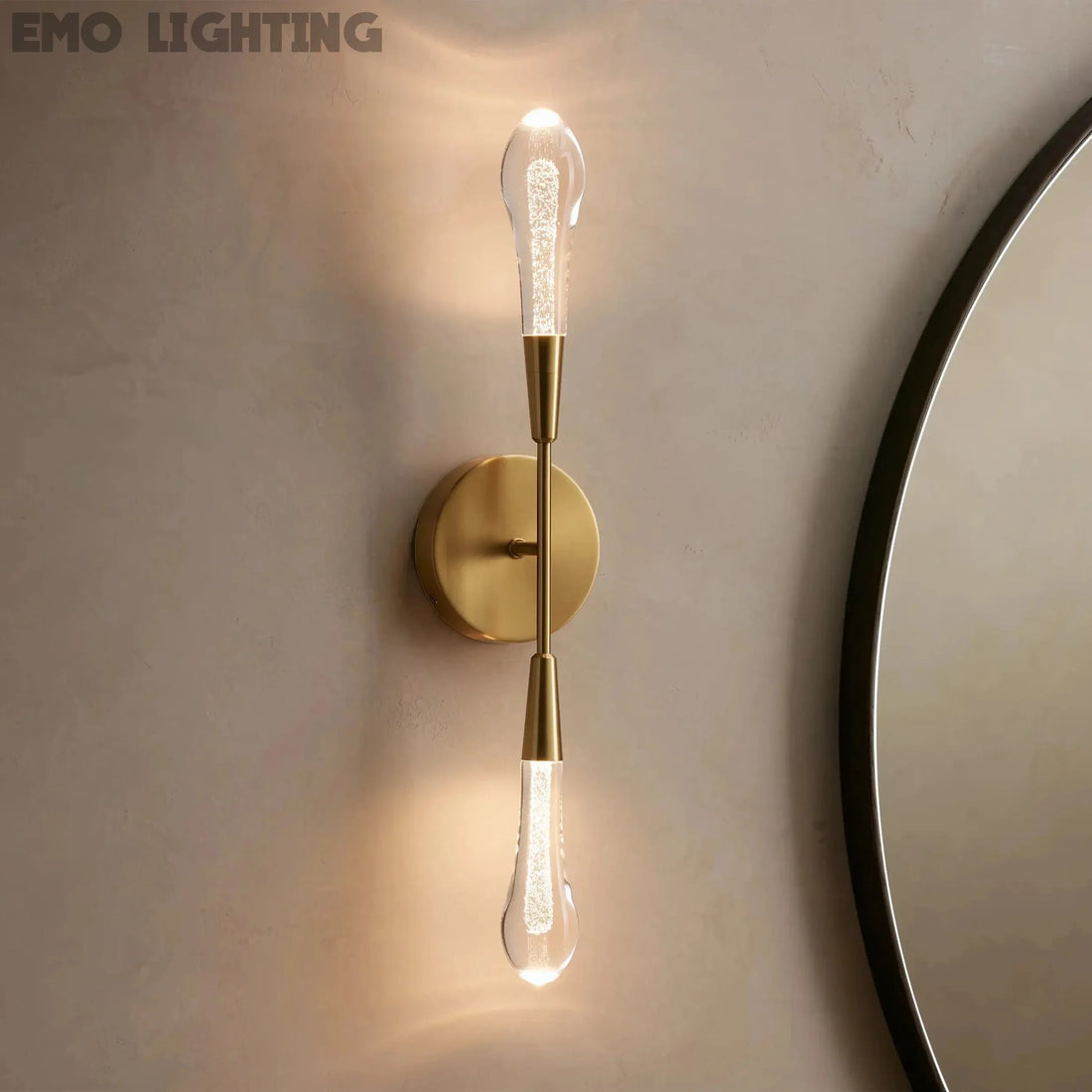 Gold wall sconce with a round mirror on a beige wall
