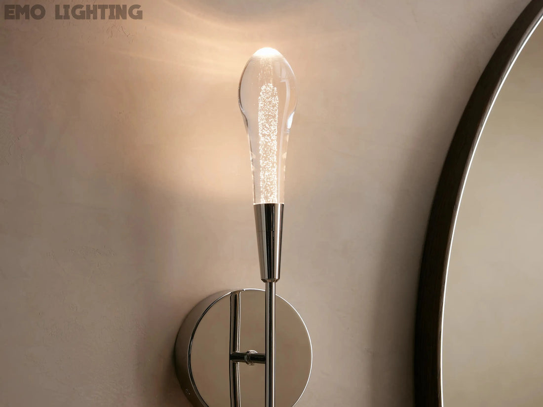 Gold wall sconce with a round mirror on a beige wall